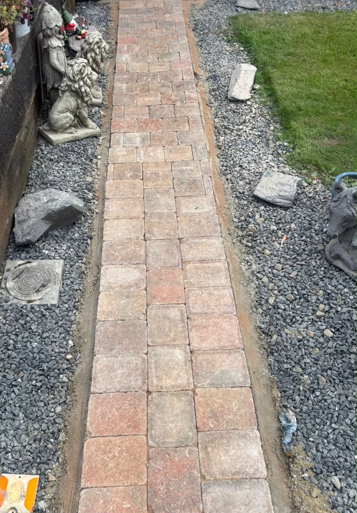 Block paved garden pathway with gravel borders